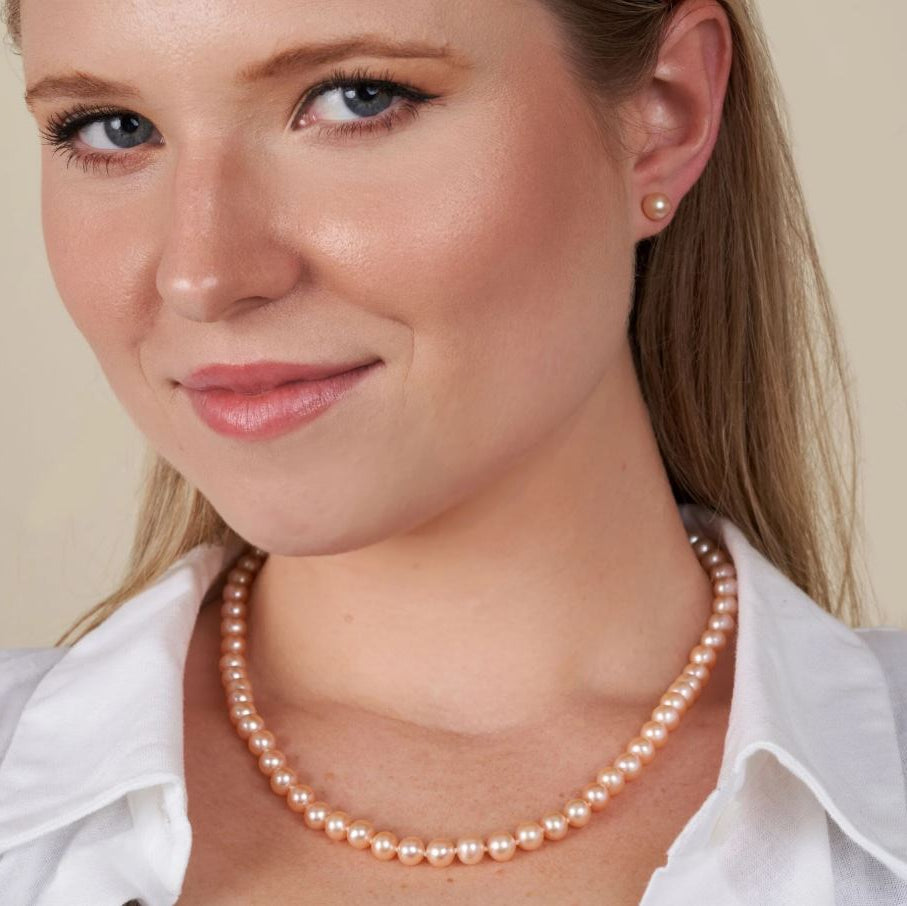 Woman wearing a pearl necklace with a plain background
